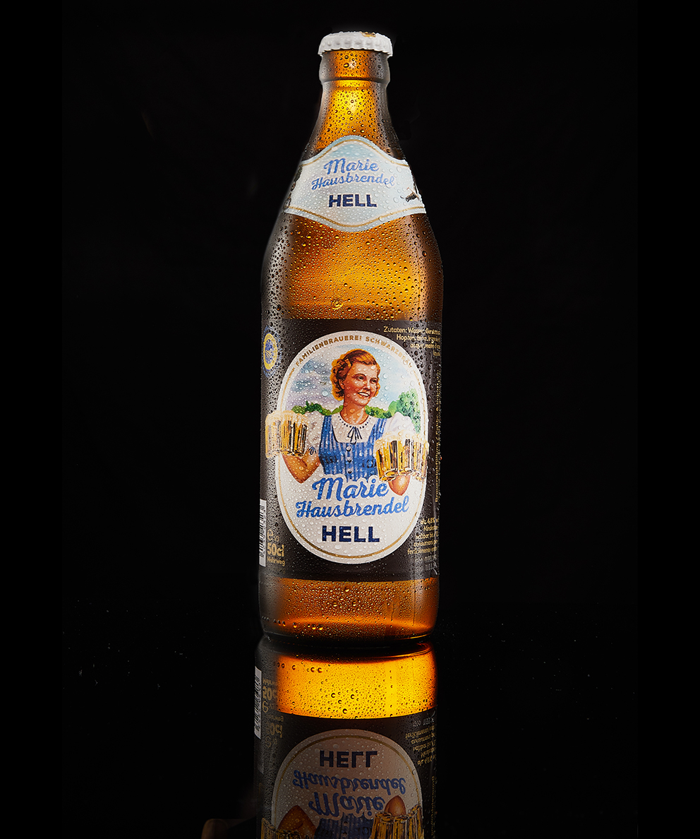 Marie Hausbrendel Hell bottle glowing with condensation against a reflective black surface