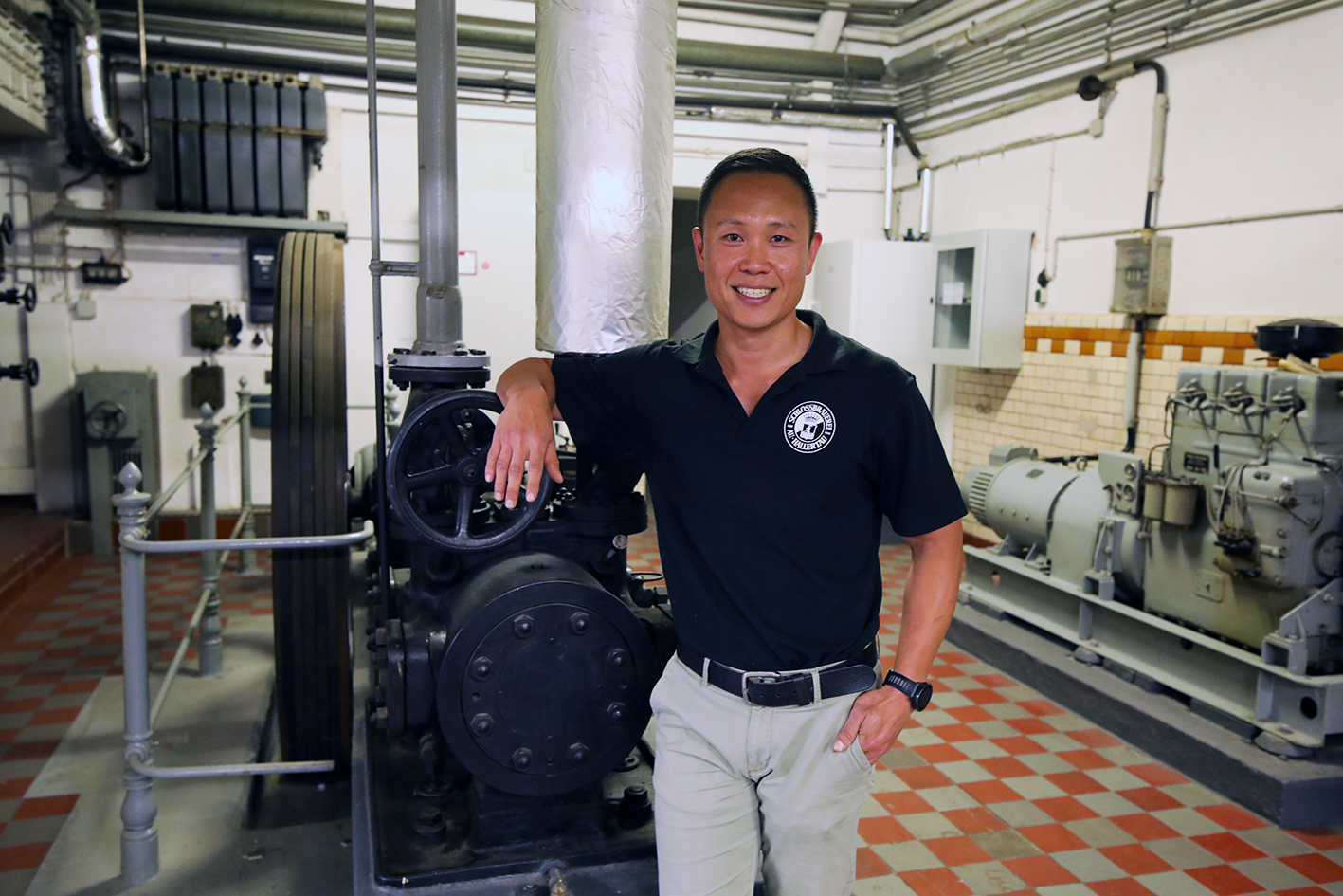 Brewmaster standing beside the brewing machinery inside the brewery