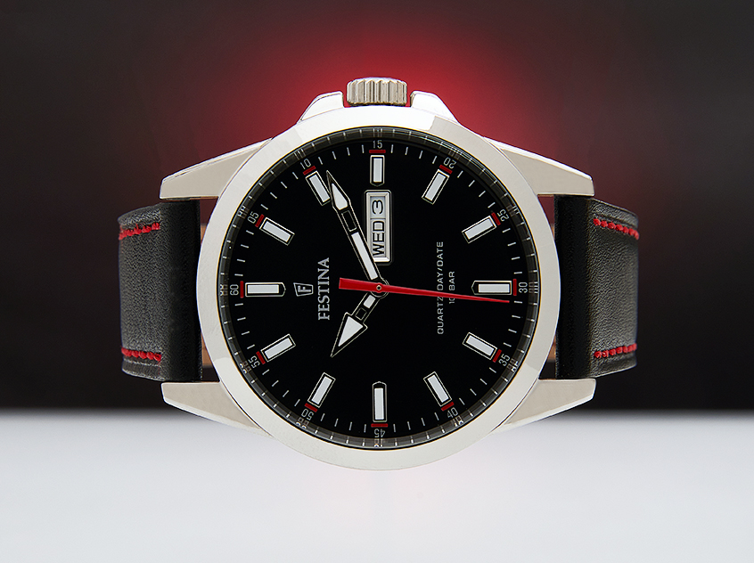 Festina watch with black face and red second hand against a subtle red glow