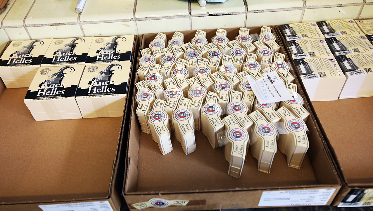 Boxes of Auer Helles neck and body labels waiting beside the labelling machine