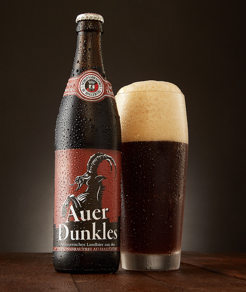 Auer Dunkles bottle beside a filled glass of dark beer with foam