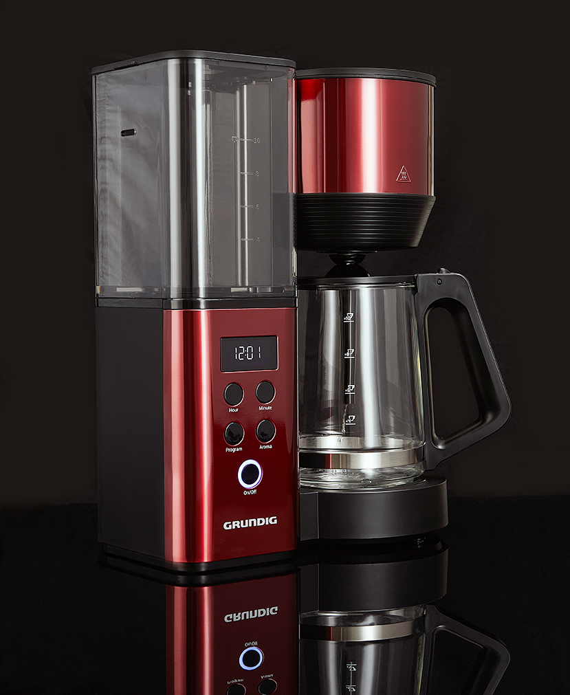 Red and black Grundig filter coffee machine on a reflective black surface