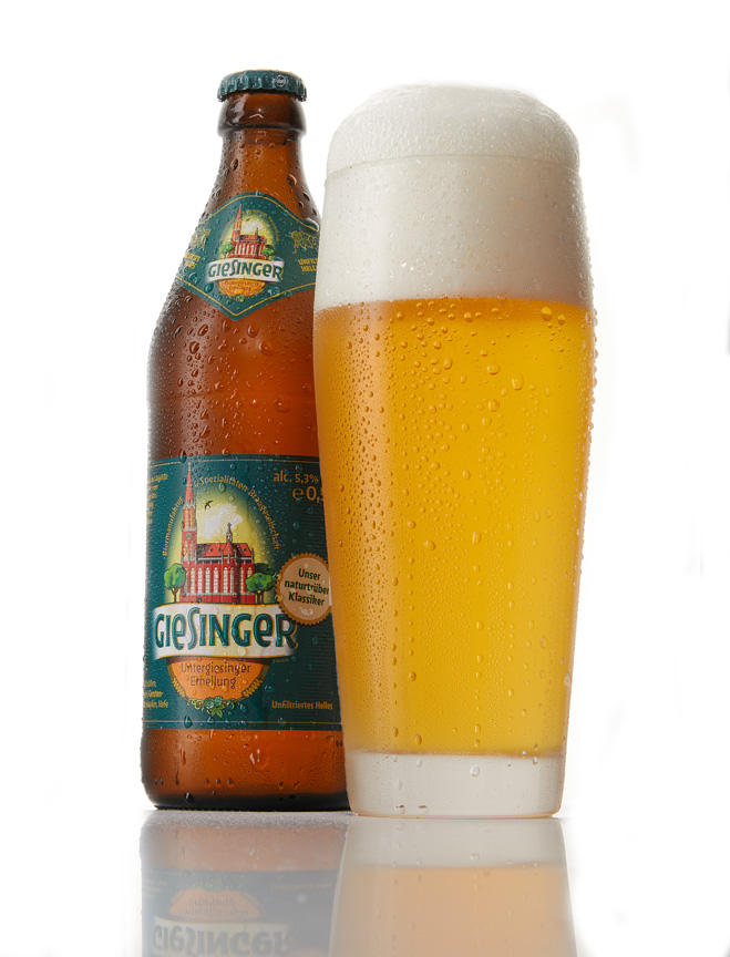 Giesinger Untergiesinger Erhellung bottle beside a tall Weissbier glass filled with unfiltered Helles on a bright white background