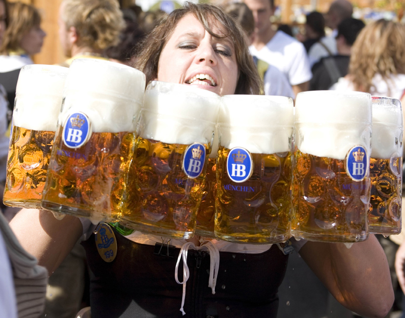 A server carrying an armful of full Hofbräu beer steins through the crowd