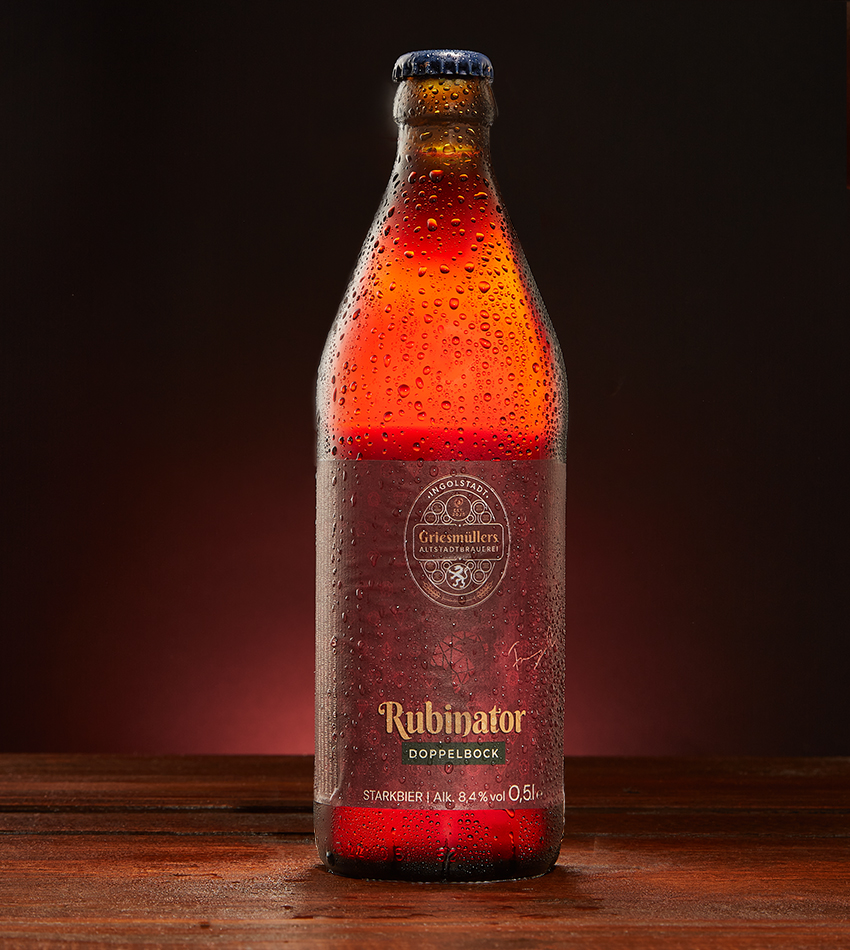 Griesmüllers Rubinator Doppelbock bottle lit against a warm red backdrop