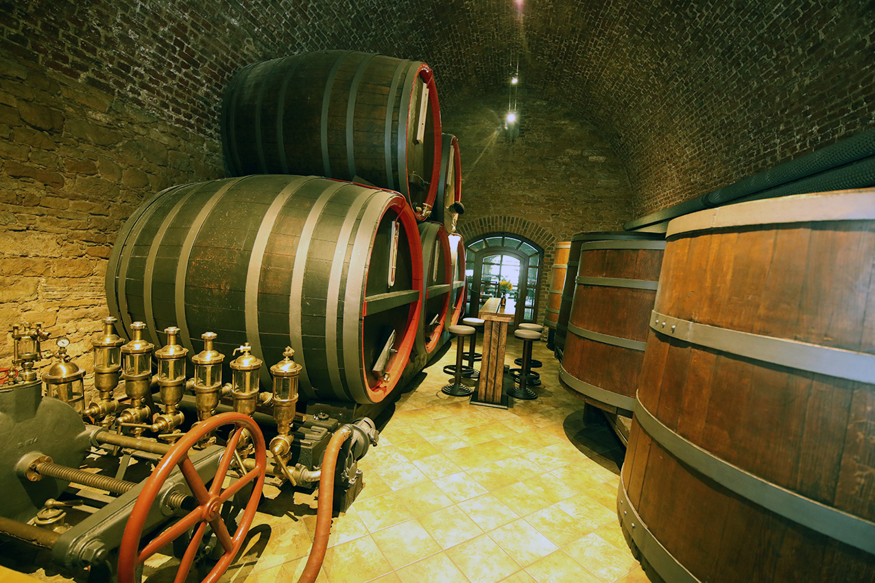 Wooden brewing barrels and brass fittings in the vaulted historic cellar