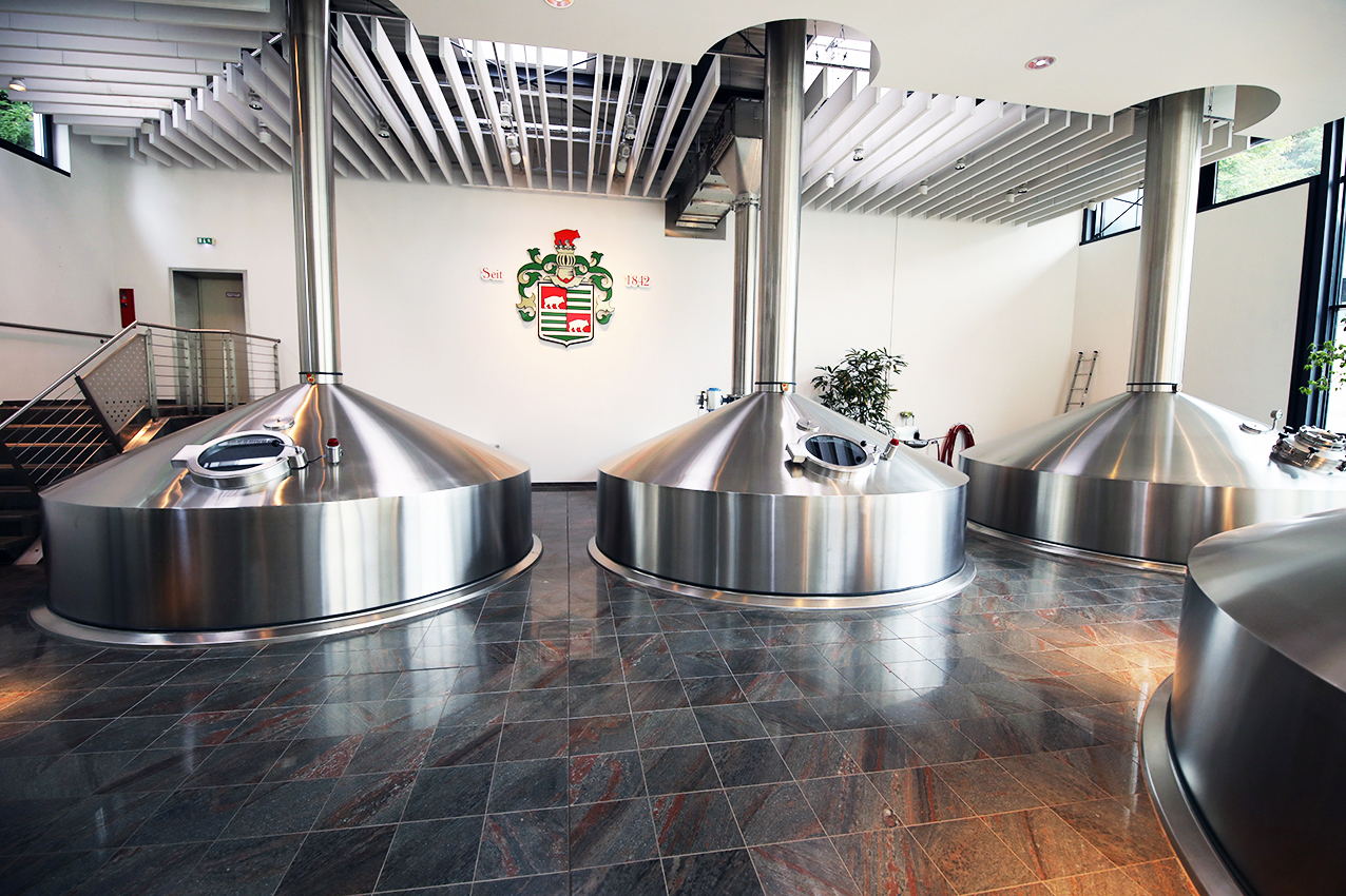 The modern brewhouse at Privatbrauerei Ernst Barre, with the family coat of arms above the copper-clad vessels